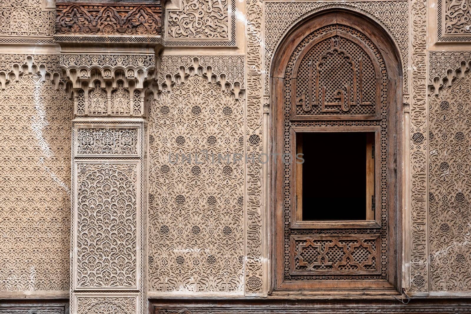 Fes, Morocco - April 04, 2023 - Rich decorated facade in the courtyard of the Medersa Attarine in Fes, Morocco