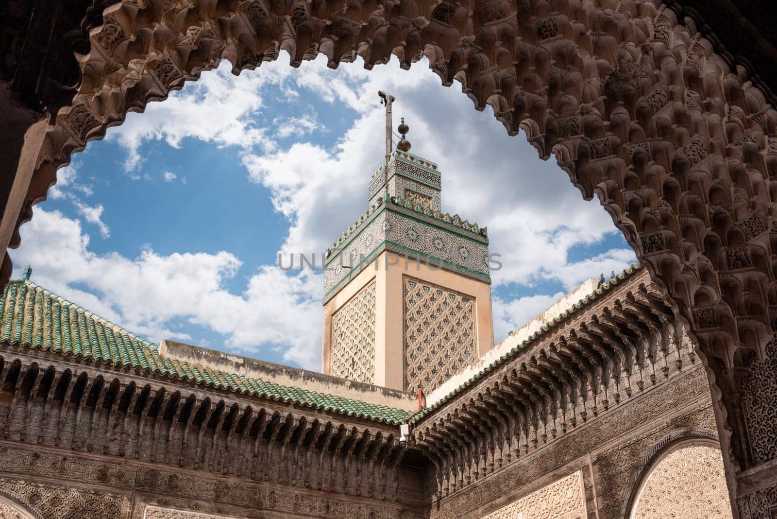 Fes, Morocco - April 05, 2023 - Traditional oriental facade at the courtyard of madrasa Bou Inaniya in the medina of Fes, Morocco