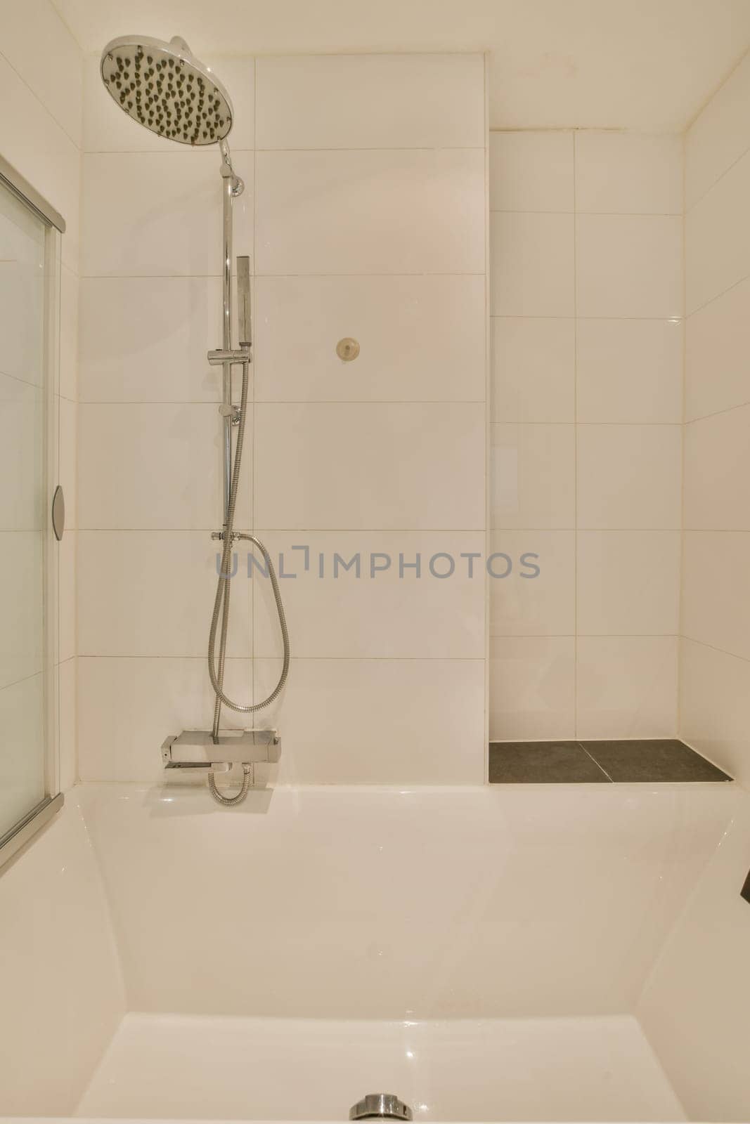 a shower with a shower head in a white bathroom by casamedia