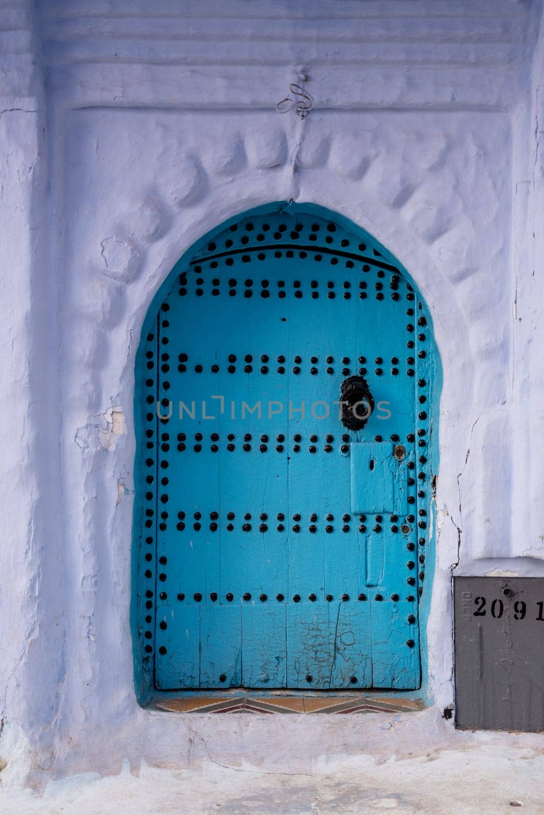 Vibrant blue colored wooden door in downtown Chefchaouen, Morocco