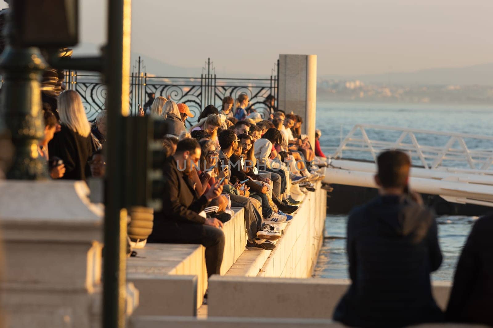 14 november 2023, Lisbon, Portugal - Group of People looking to sunset near a bridge
