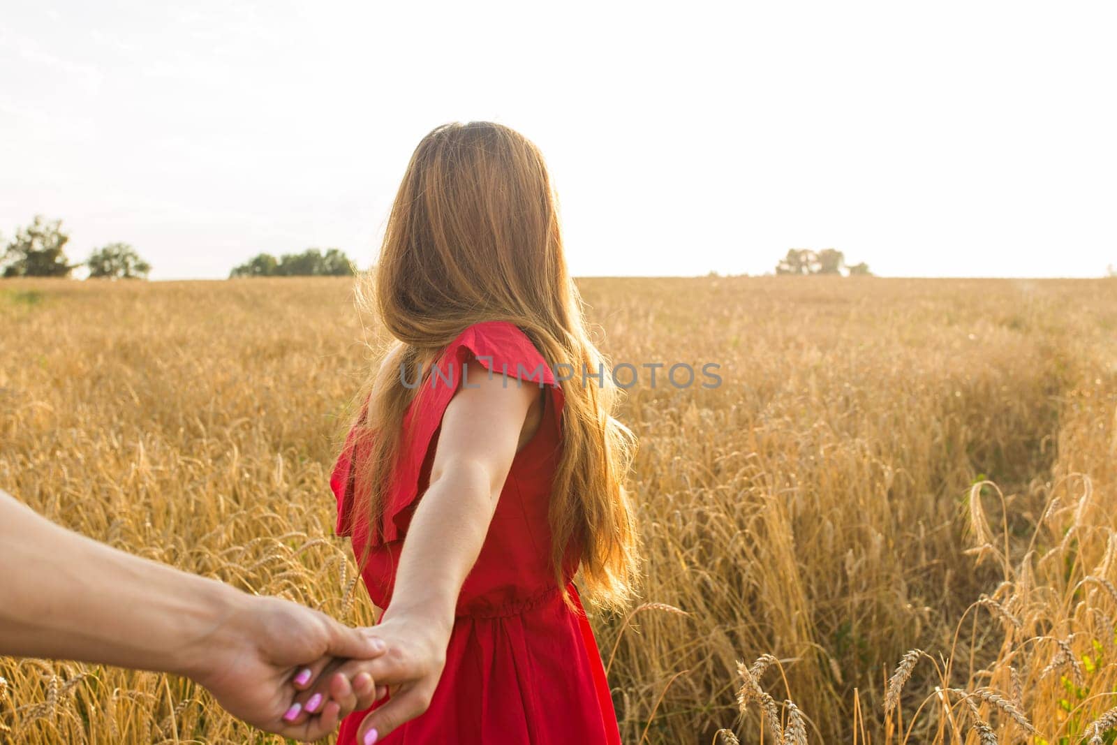 Follow me, Beautiful young woman holds the hand of man in a wheat field by Satura86