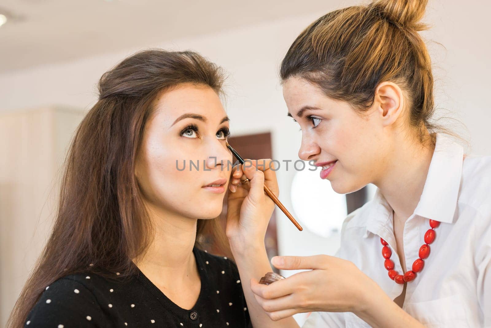 Closeup of a makeup artist applying make-up. by Satura86