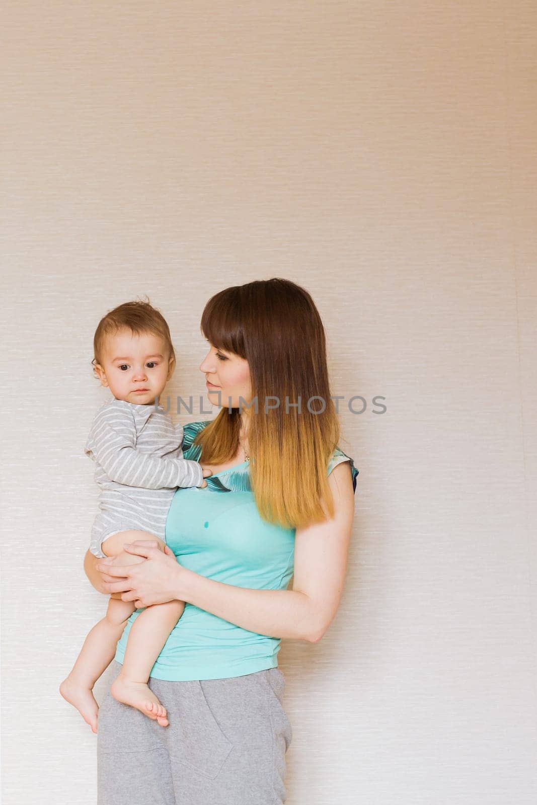 Happy mother with adorable baby boy in the bedroom