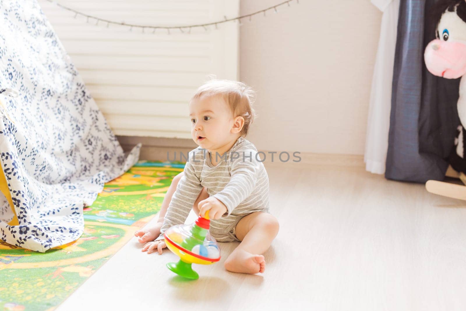 Little cute baby boy plays in his room