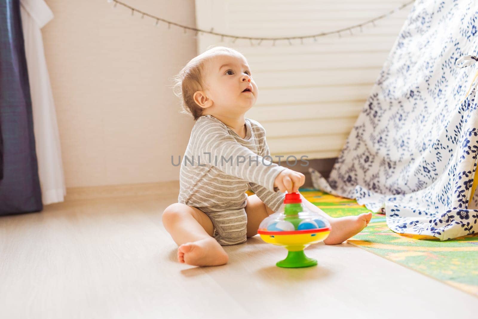 Little cute baby boy plays in his room