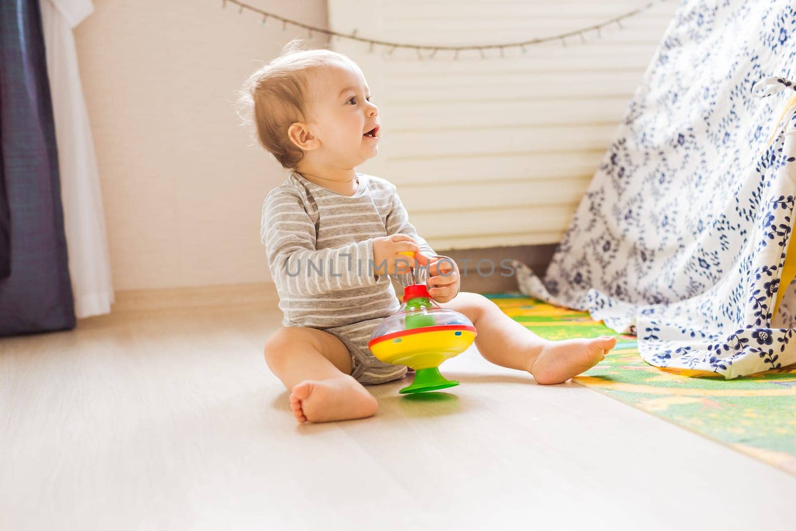 Little cute baby boy plays in his room