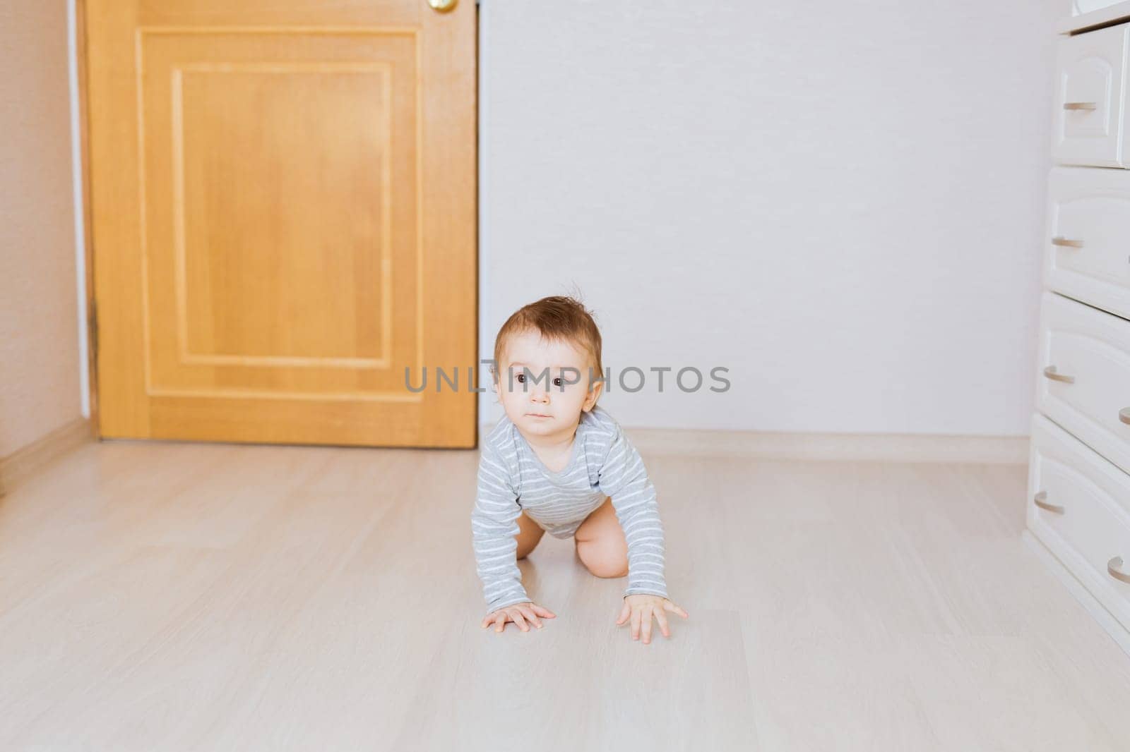 Portrait of a crawling baby boy in the bedroom