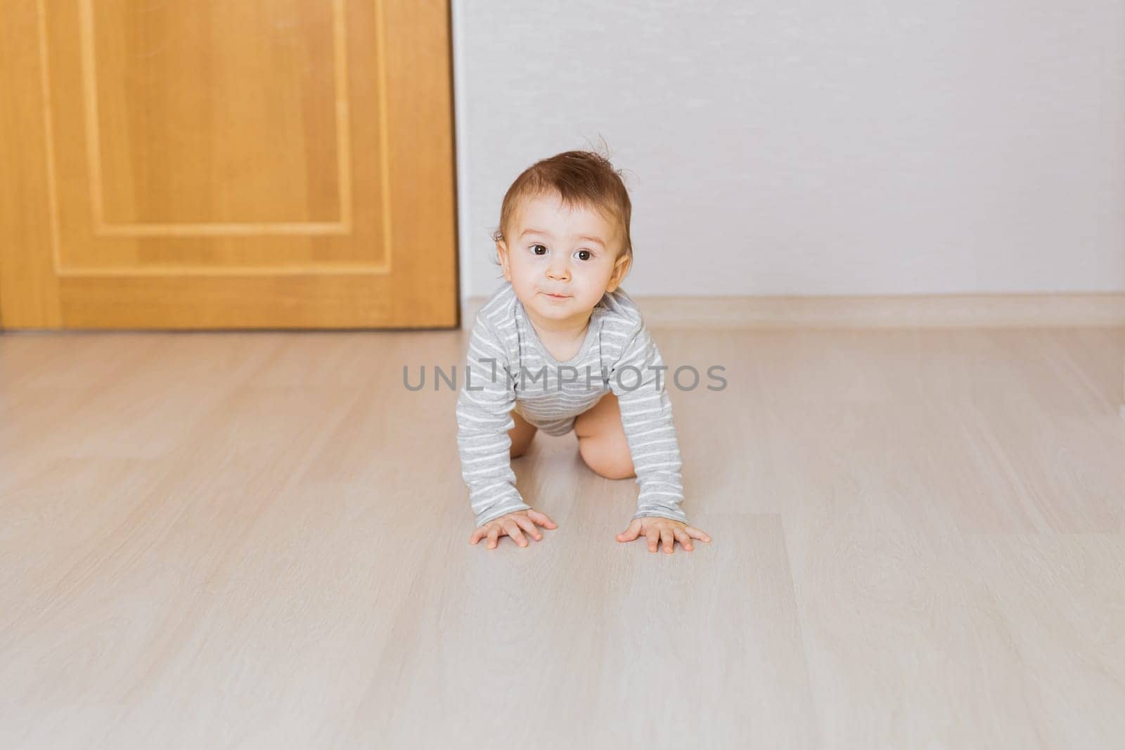 Portrait of a crawling baby boy in the bedroom