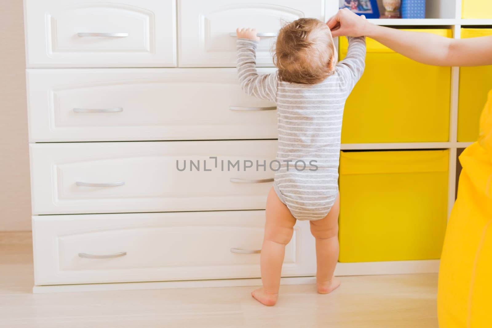 little boy first steps with the help of mom.