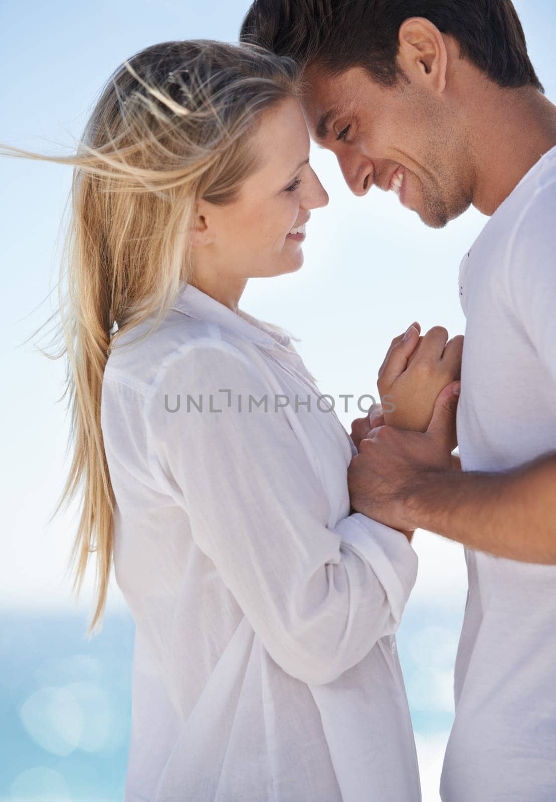 Couple, beach and happy with love, support and care on a date by the sea with romance on vacation. Holiday, ocean and outdoor with summer travel in nature relax on a break and trip by the water.