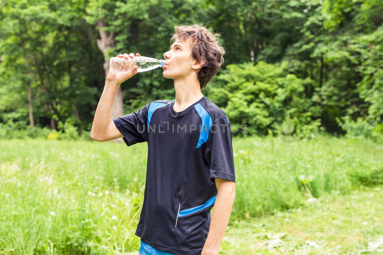 Man having break from sport training and drinks water.