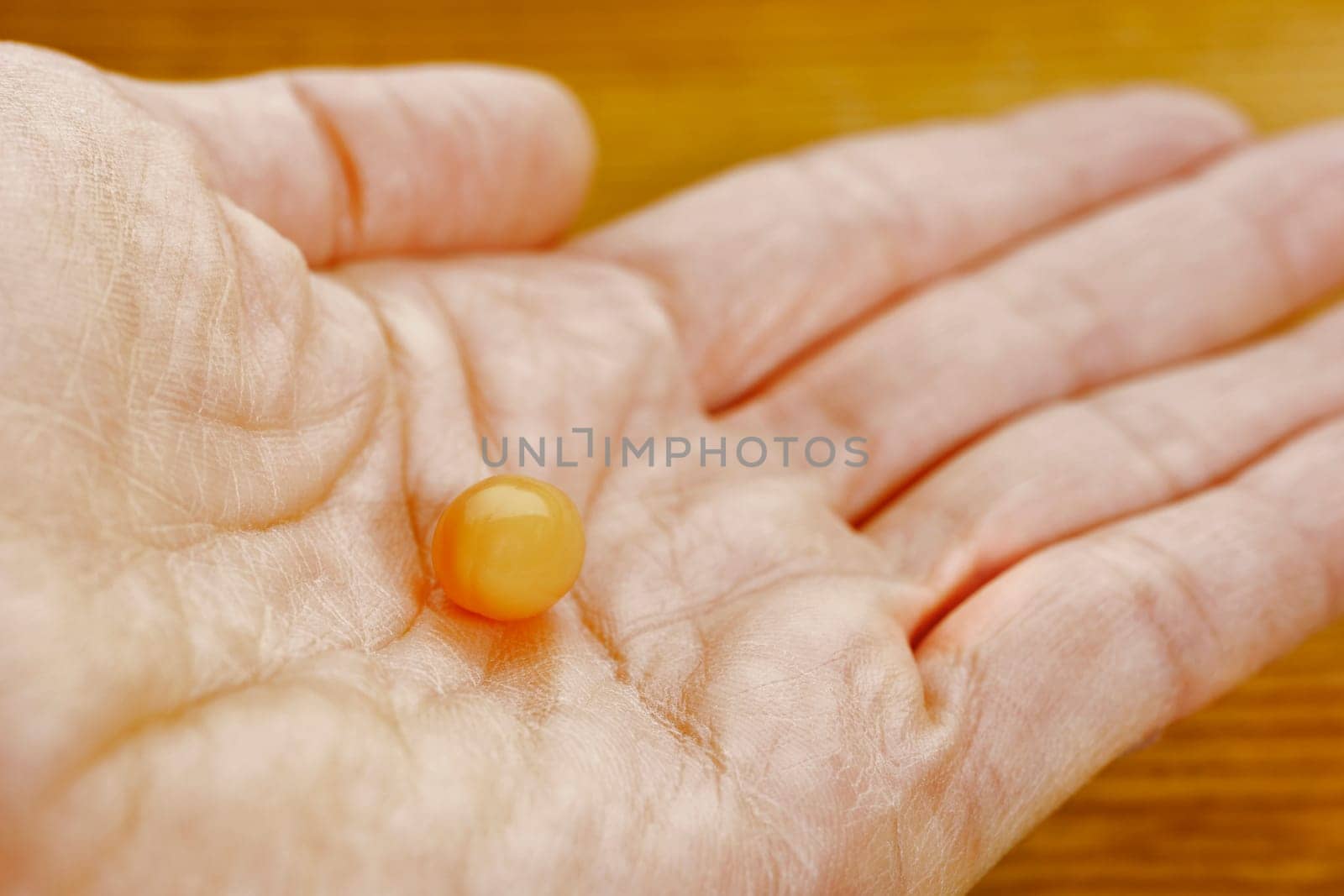 Orange pill in female hand by victimewalker