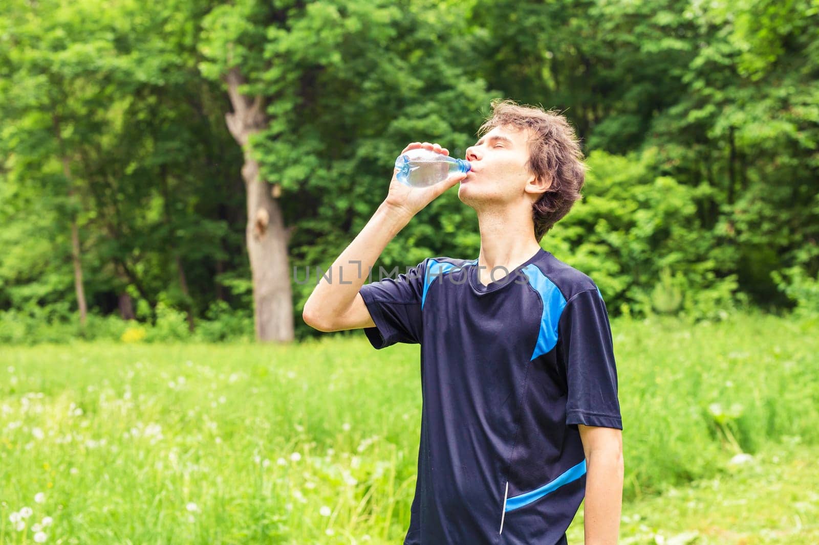 Man having break from sport training and drinks water by Satura86