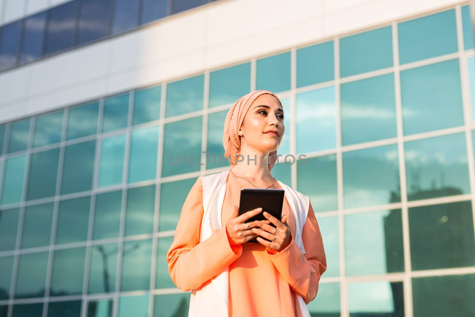 Portrait of an Arab businesswoman in hijab holding a tablet. by Satura86