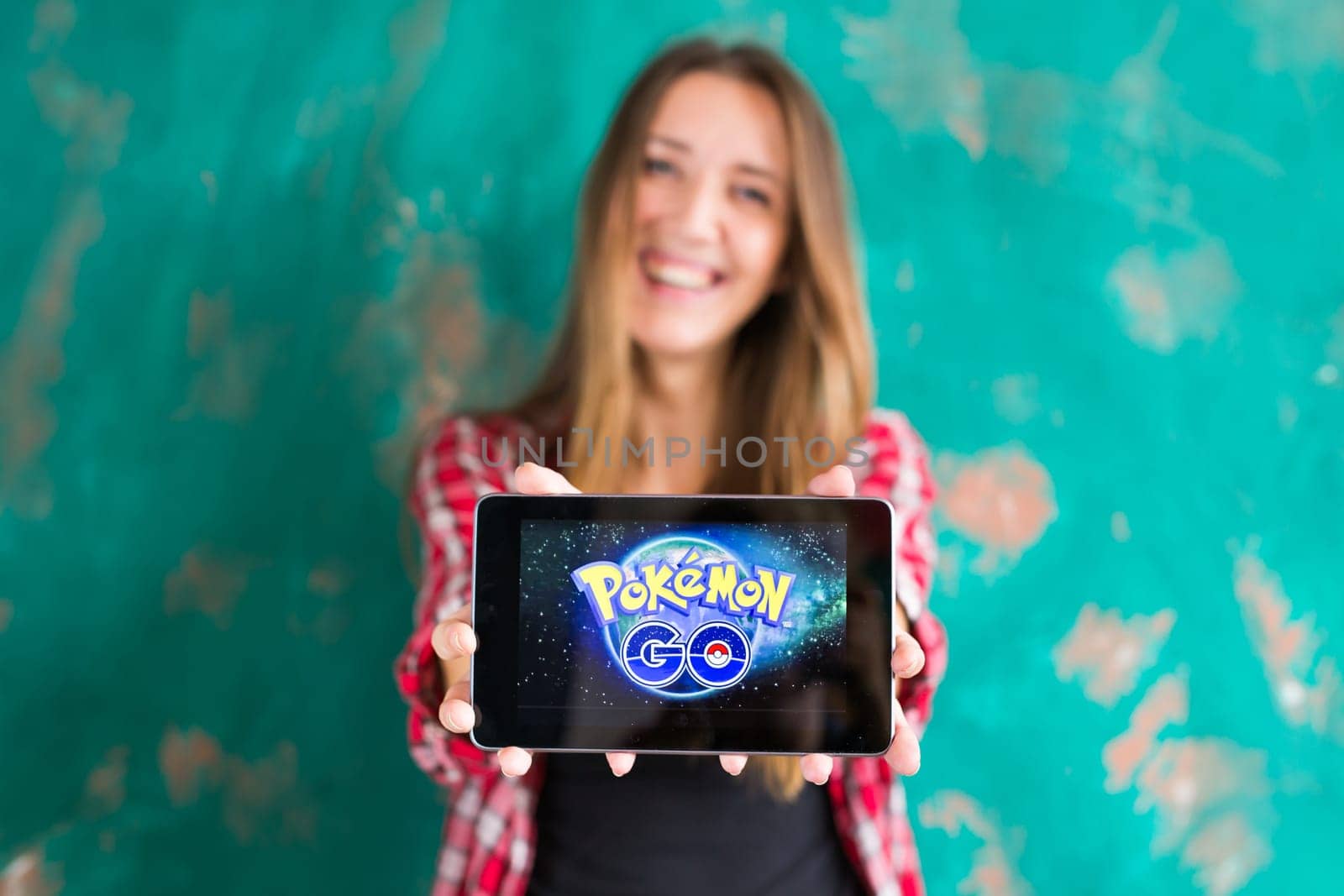 Ufa, Russia. - July 29: Woman show the tablet with Pokemon Go logo by Satura86