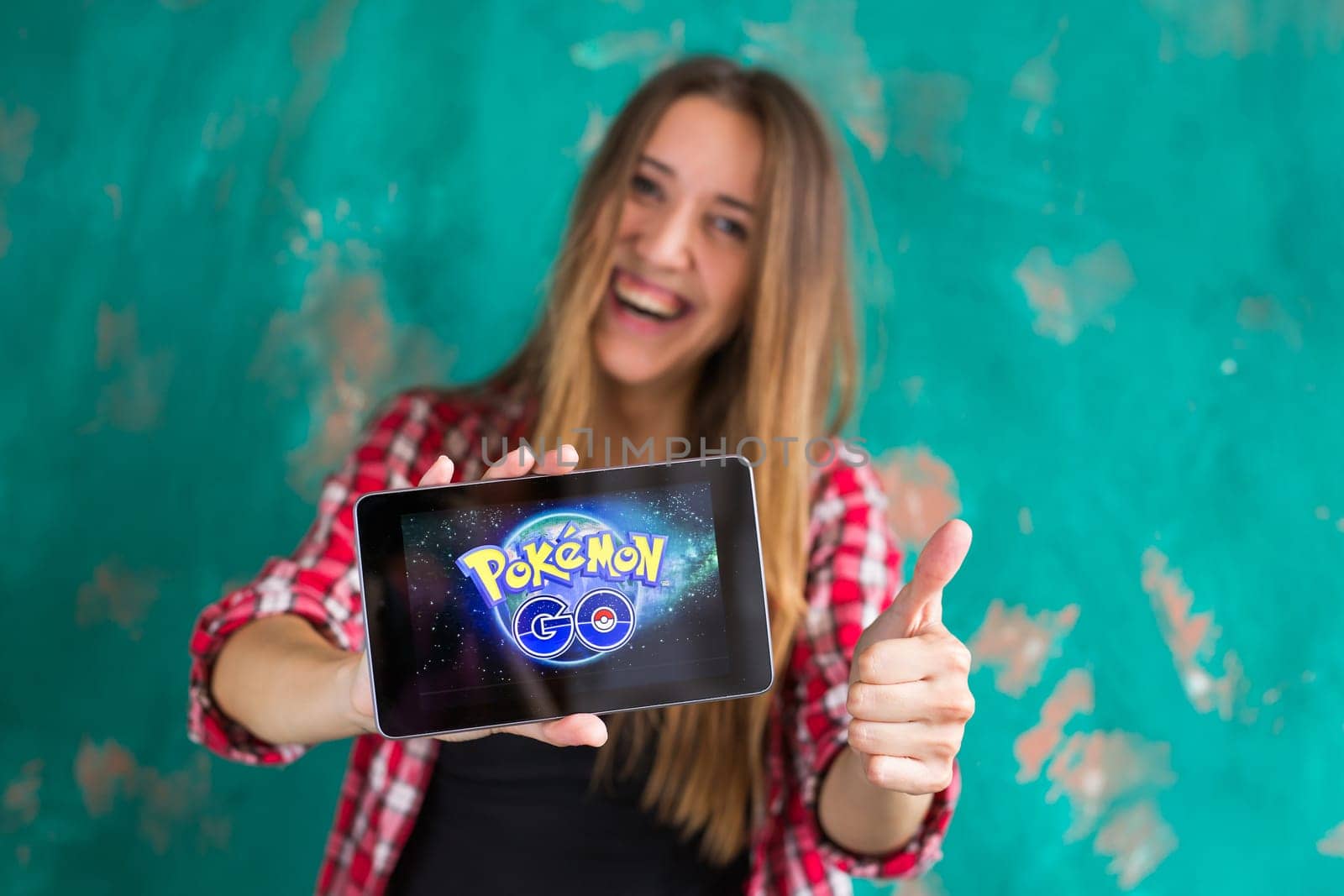 Woman show the tablet with Pokemon Go logo