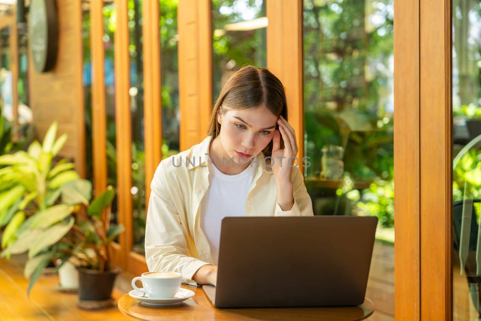 Young woman working on laptop at outdoor cafe garden. Expedient by biancoblue