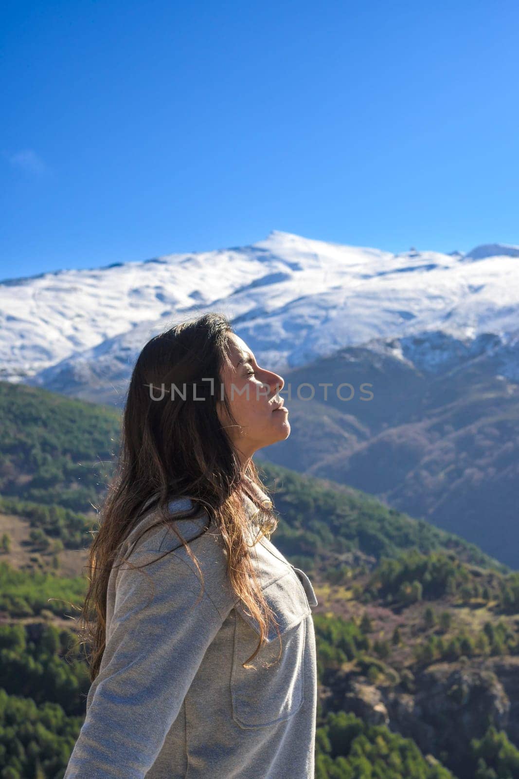 latina woman,long hair,breathing fresh air at the top of the mountain,sierra nevada spain by carlosviv