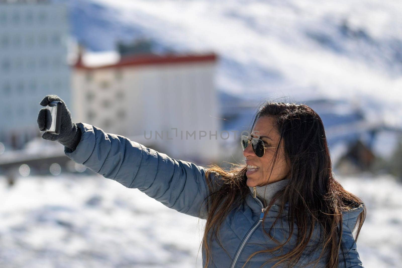 Young man taking a selfie in the mountains of sierra nevada, in the ski resort of granada.,