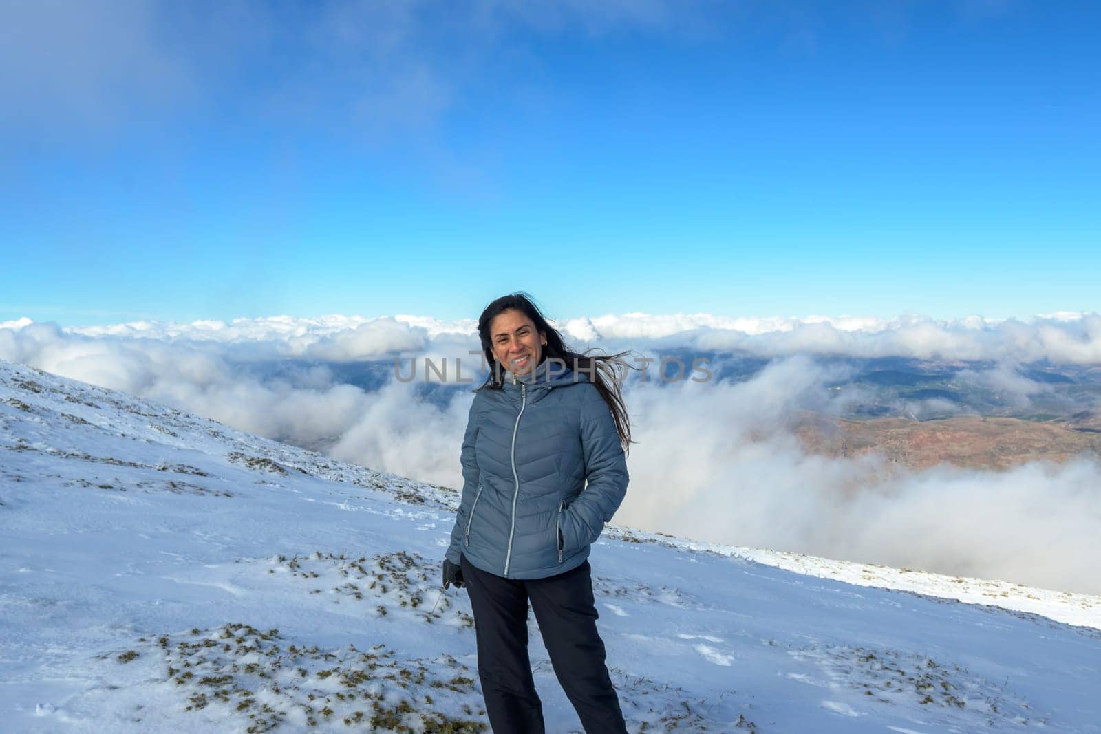 portrait of latina woman in the snow above the clouds