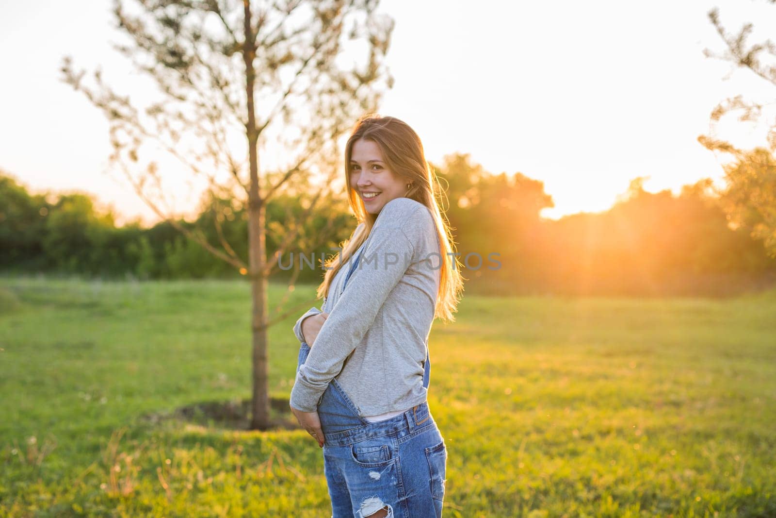 young happy pregnant woman relaxing and enjoying life in autumn nature.