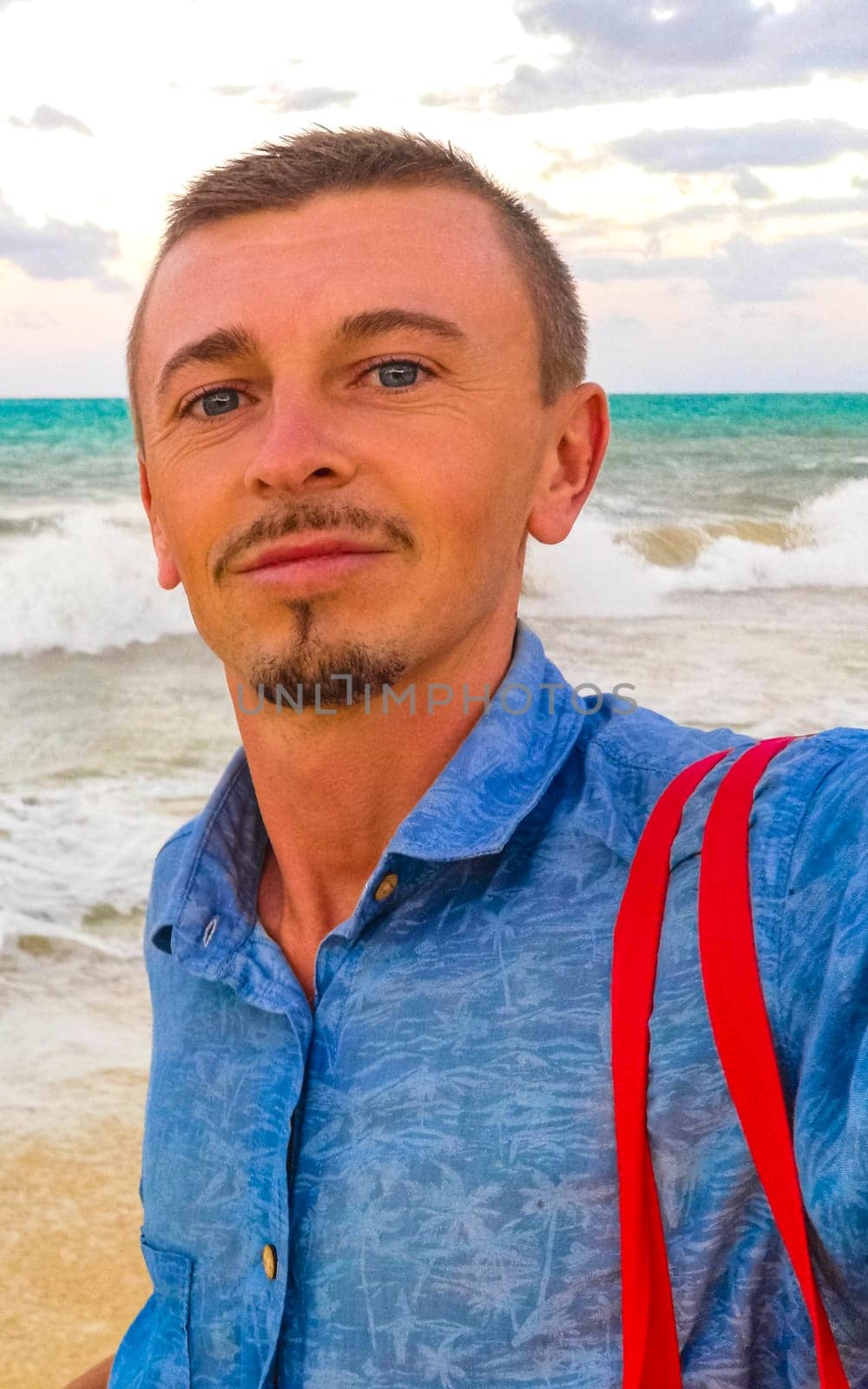 Male tourist Travelling man taking selfie photo on the beach in Playa del Carmen Quintana Roo Mexico.