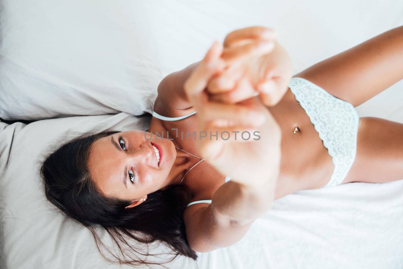 Brunette woman in lingerie lying on bed in bedroom room by Simakov