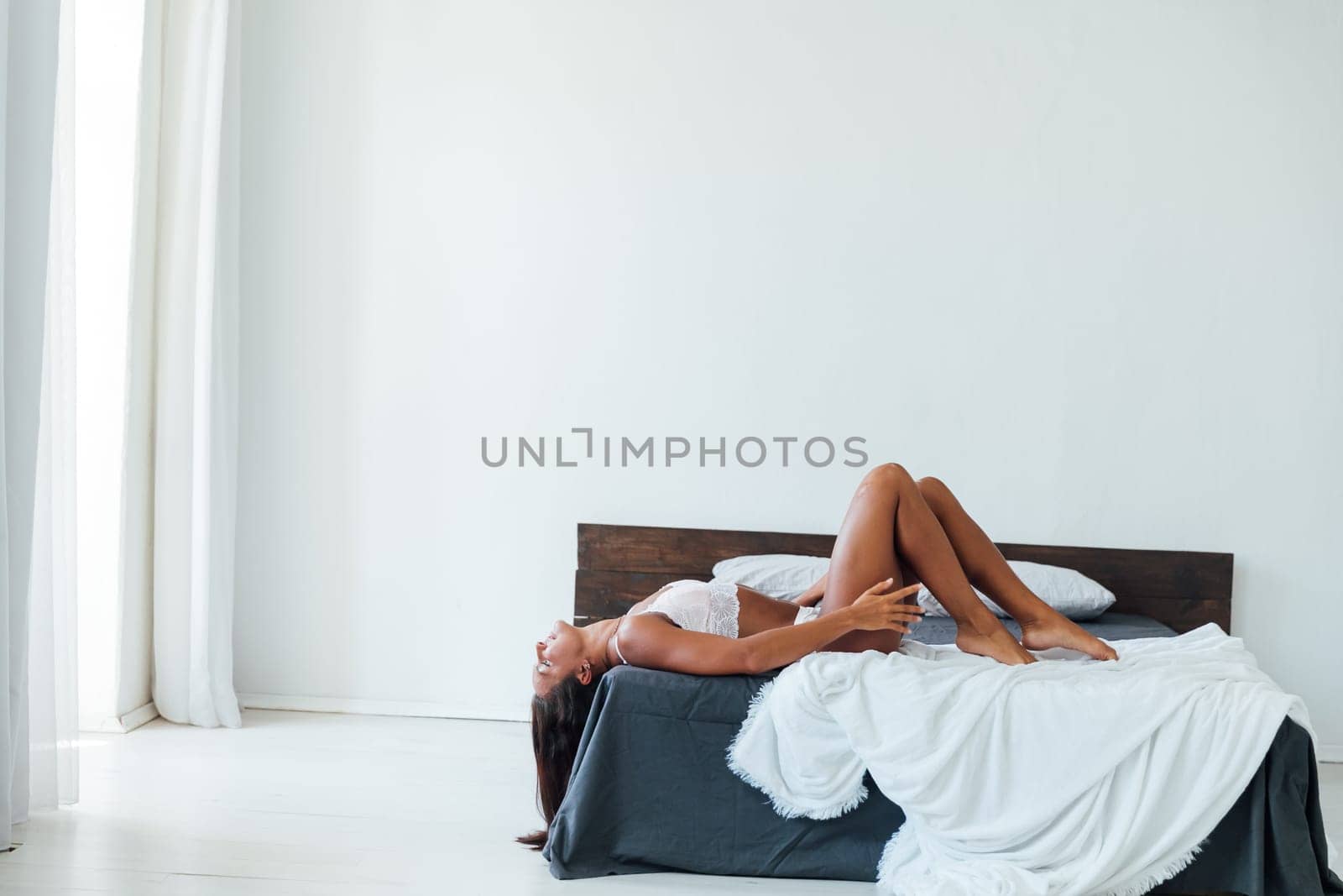 Woman in underwear lying on bed white
