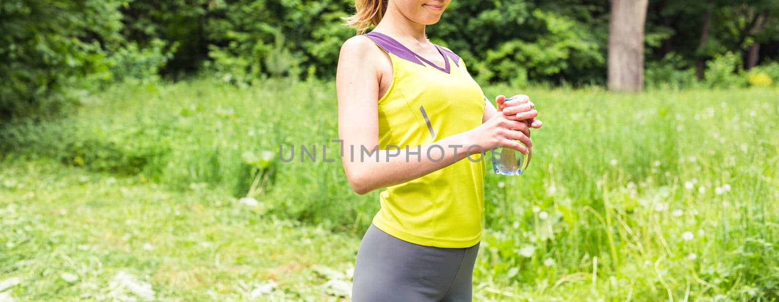 Fitness woman drinking water after work out exercising on summer outdoor portrait by Satura86