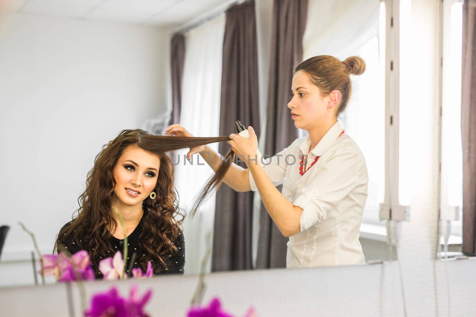 working day inside the beauty salon. Hairdresser makes hair styling