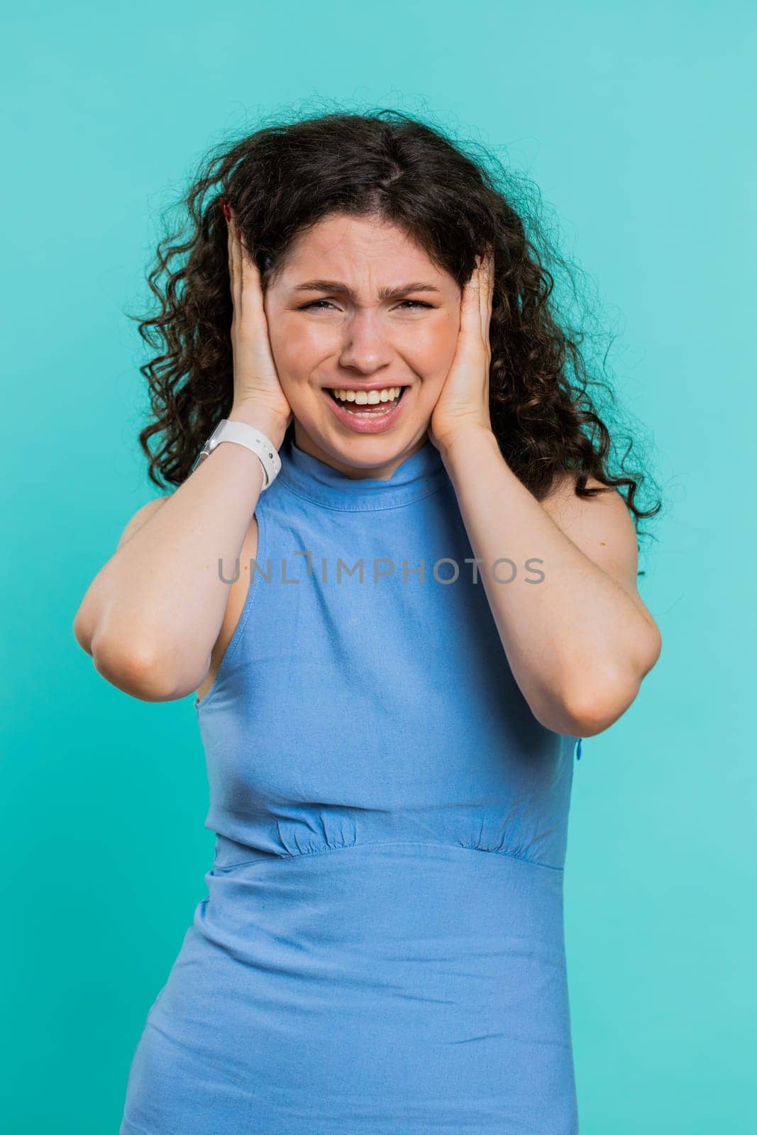 Dont want to hear and listen. Frustrated annoyed irritated woman covering ears gesturing No, avoiding advice ignoring unpleasant noise loud voices. Girl isolated alone on blue background. Vertical