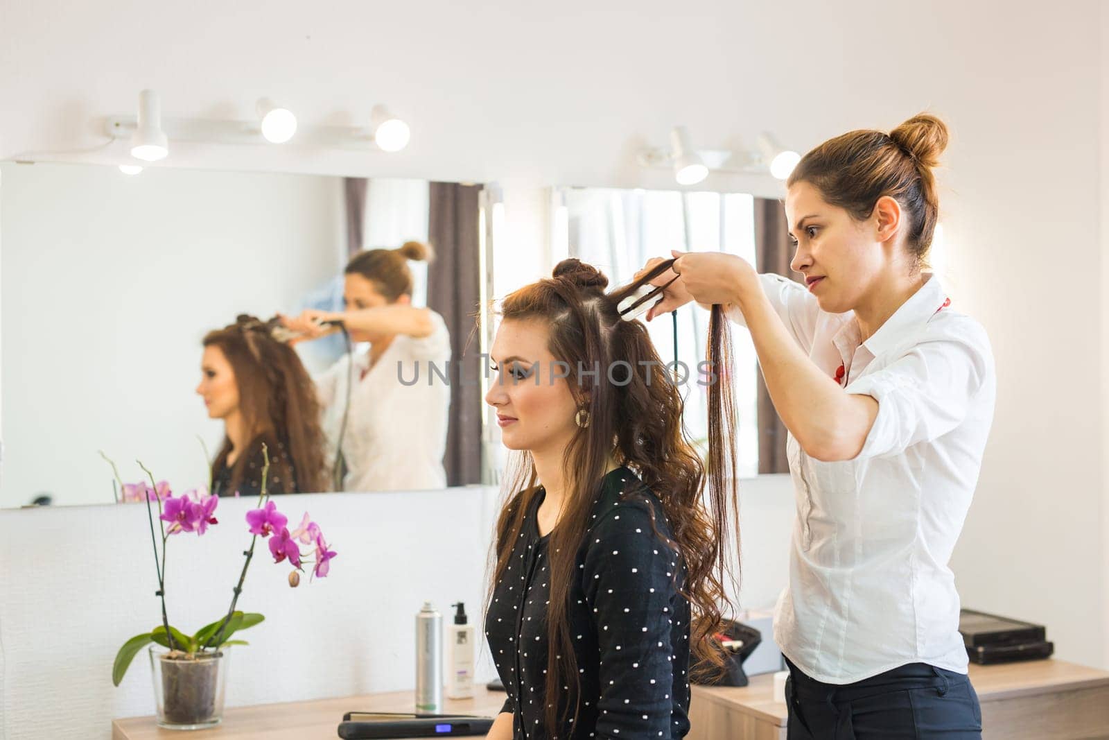 working day inside the beauty salon. Hairdresser makes hair styling