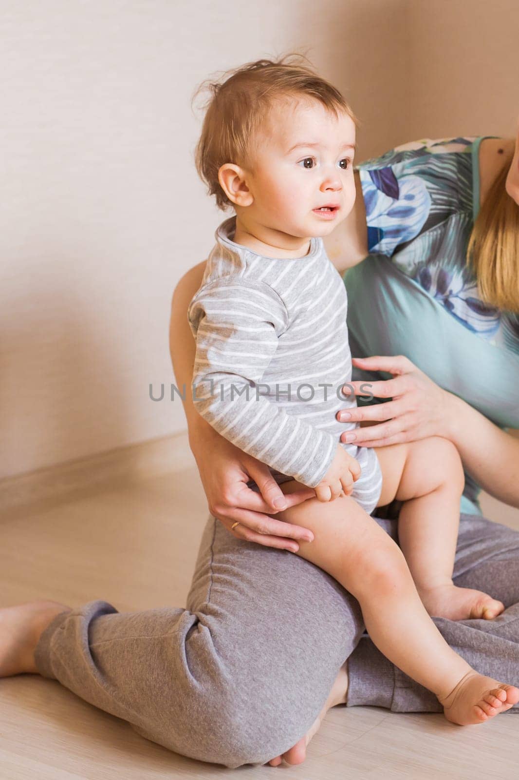 Mother holding sweet baby boy in the room