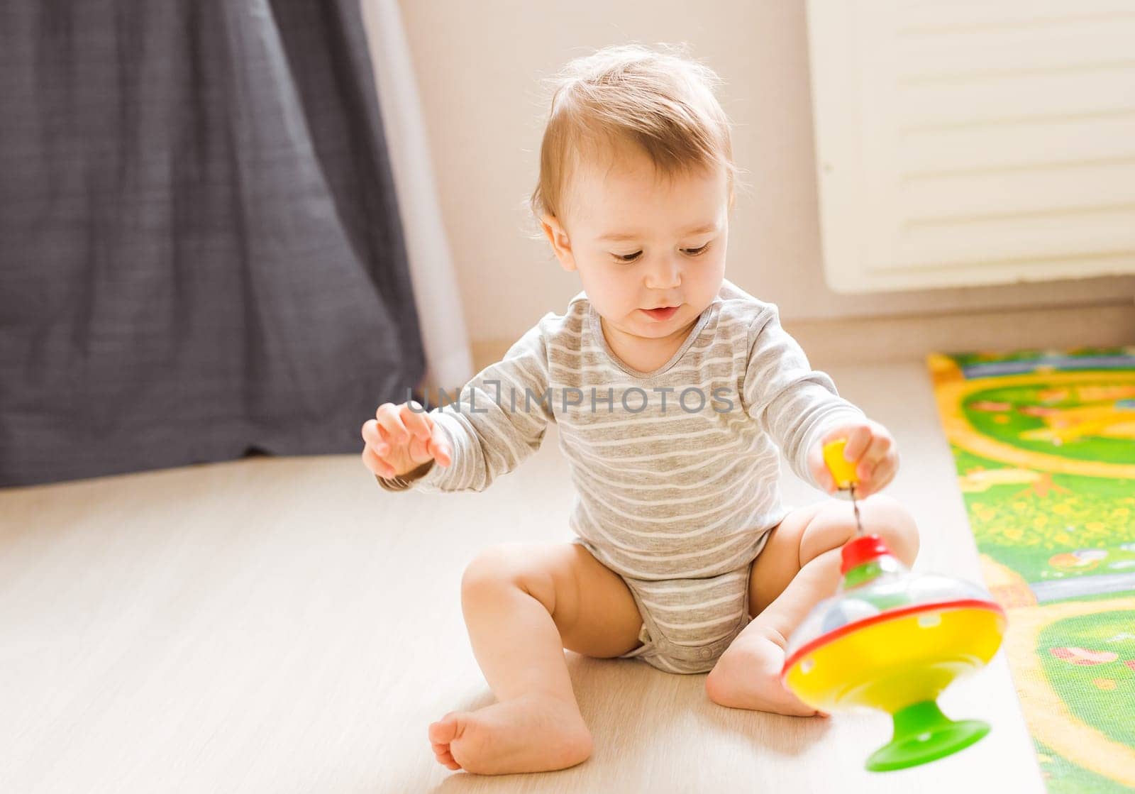 baby boy playing with toy indoors at home.