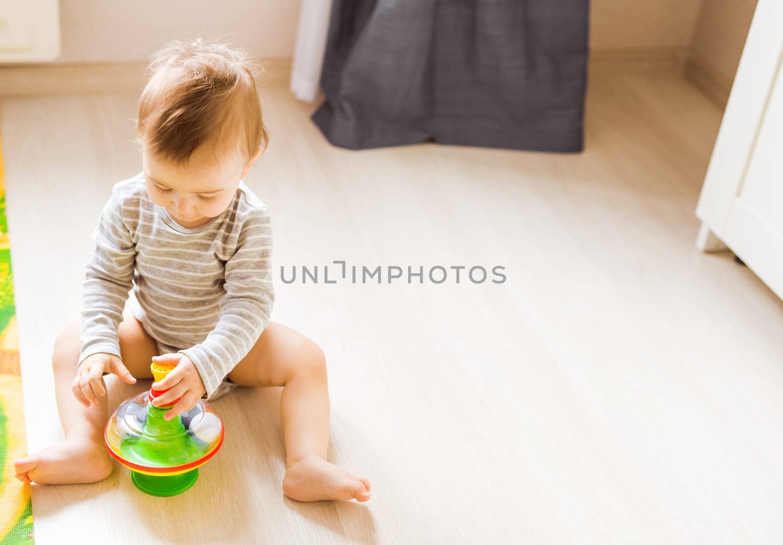 baby boy playing with toy indoors at home.