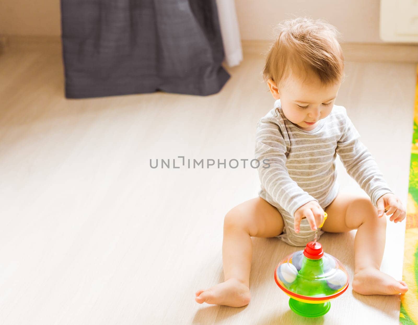 baby boy playing with toy indoors at home.