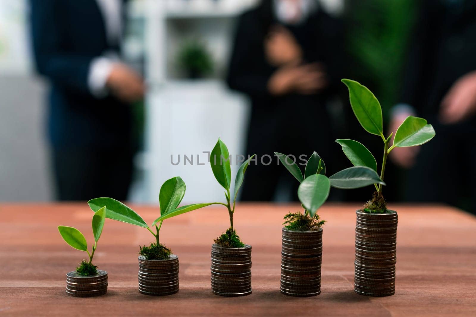 Organic money growth investment concept shown by stacking piles of coin with sprout or baby plant on top. Financial investments rooted and cultivating wealth in harmony with nature. Quaint