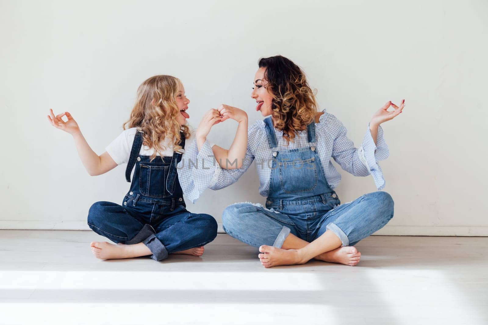 Mom and daughter show heart with hands