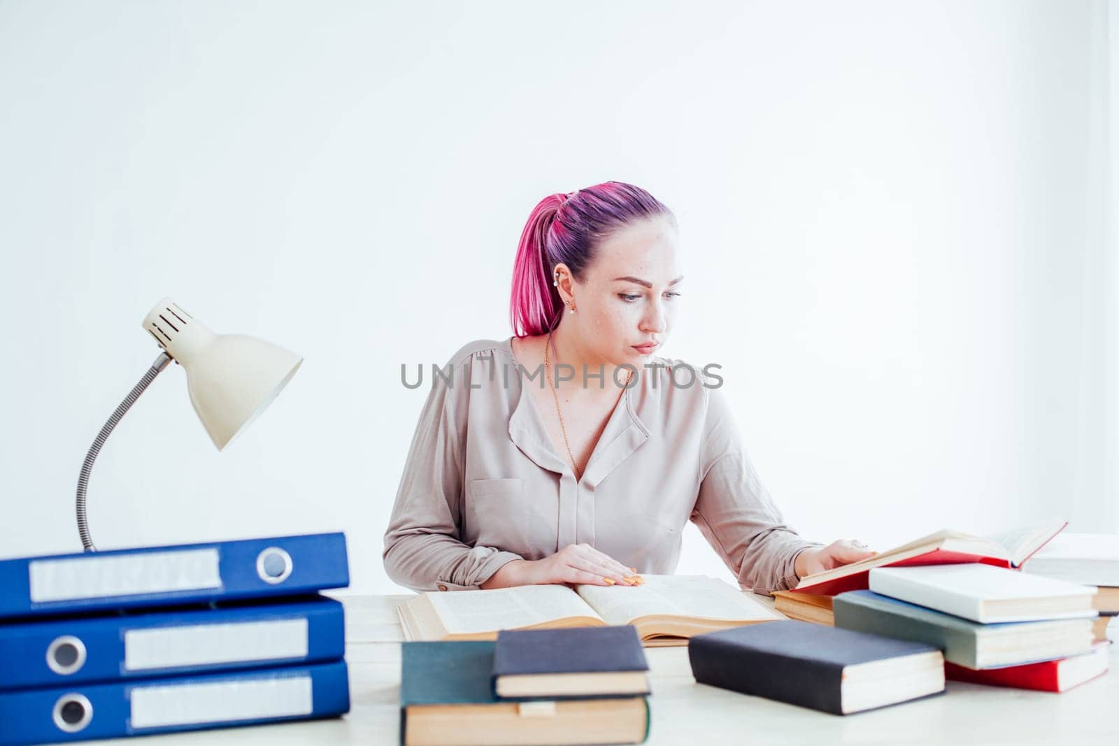 girl with pink hair sitting at a table reading a book by Simakov