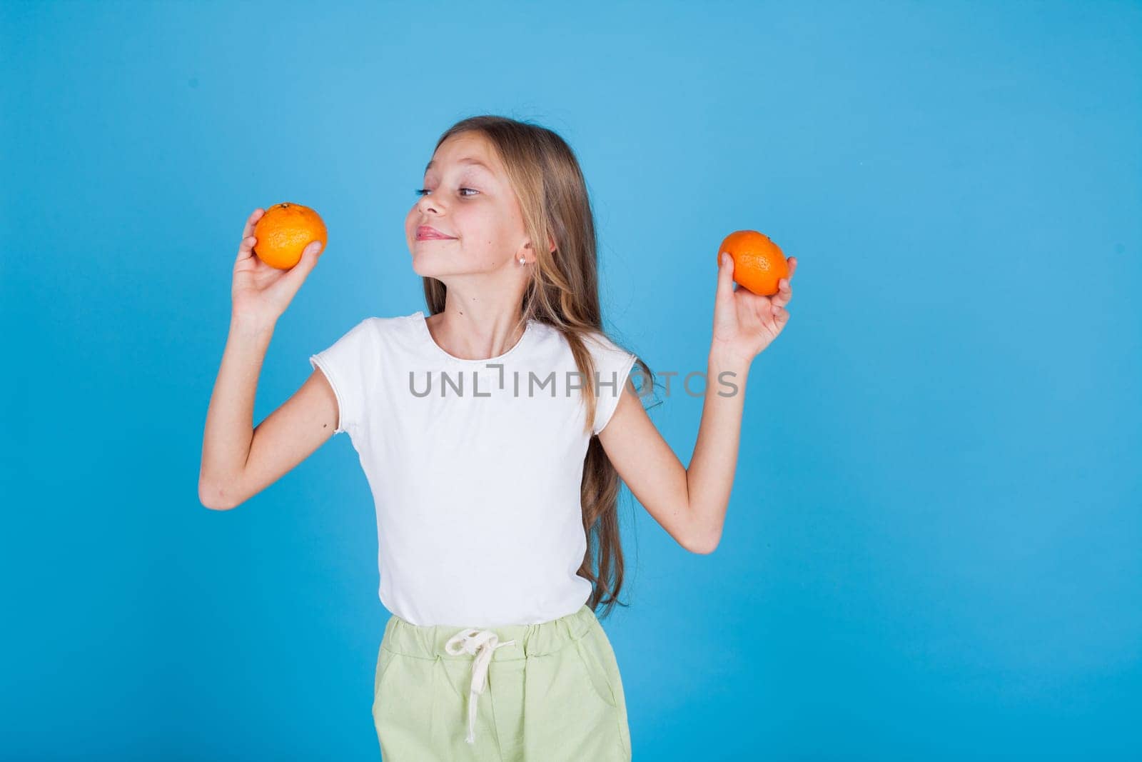 Beautiful girl holds ripe oranges