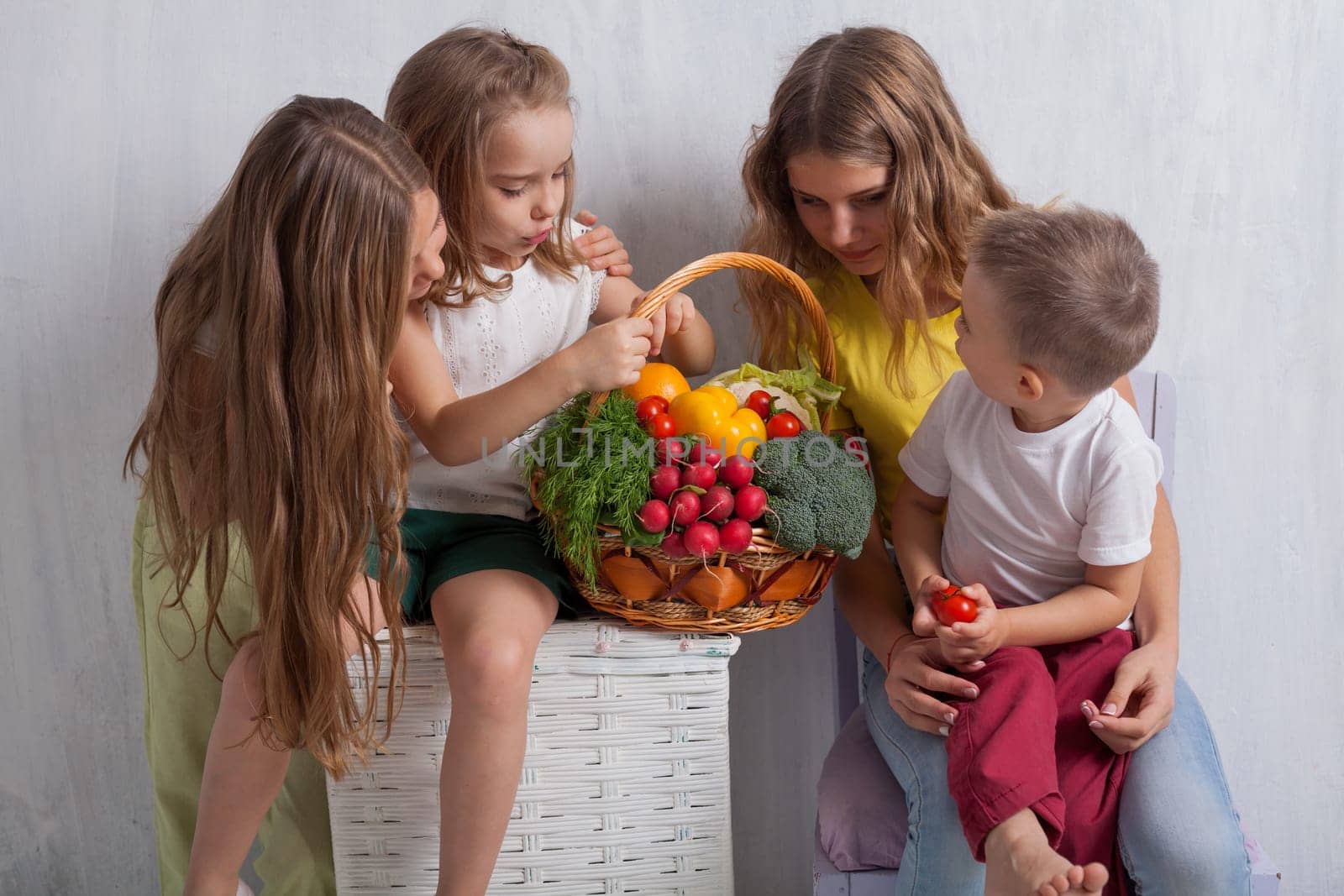 Girls and boy hold ripe vegetables and fruits by Simakov