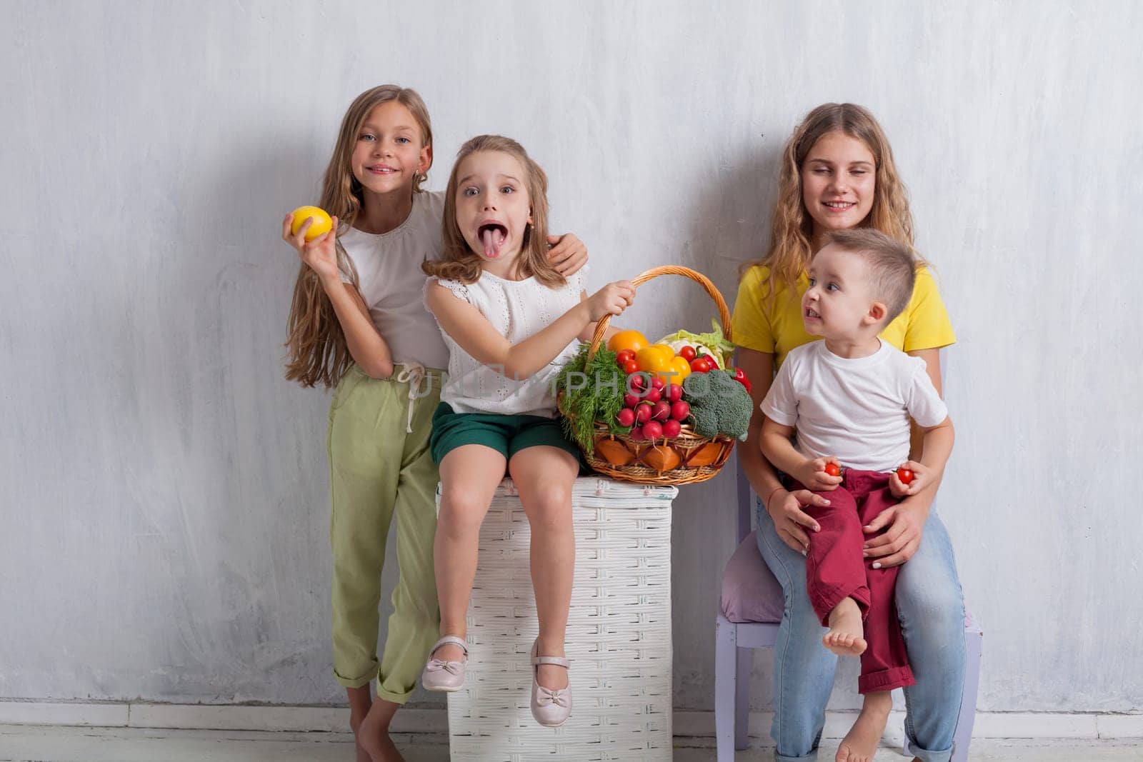 Girls and boy hold ripe vegetables and fruits by Simakov