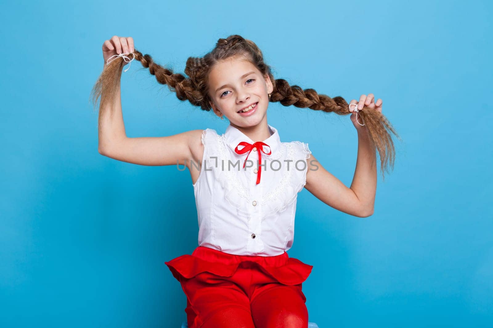 portrait of a beautiful schoolgirl with pigtails on blue background by Simakov