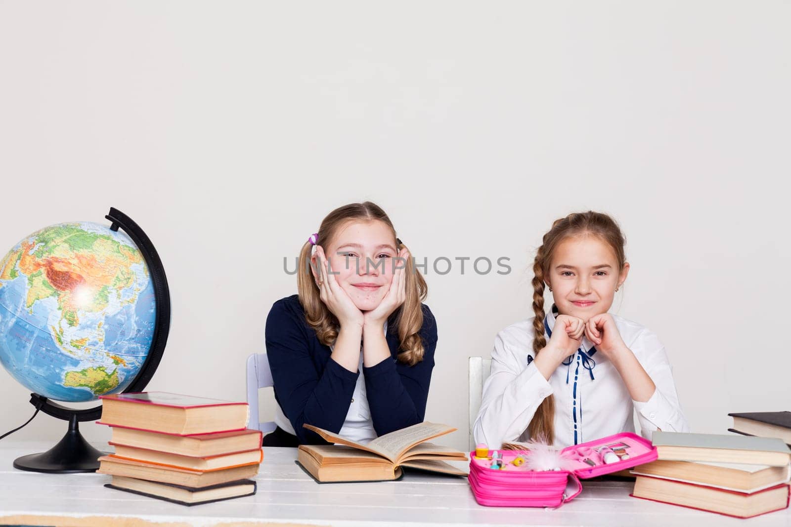 two schoolgirl at the desk in a geography class