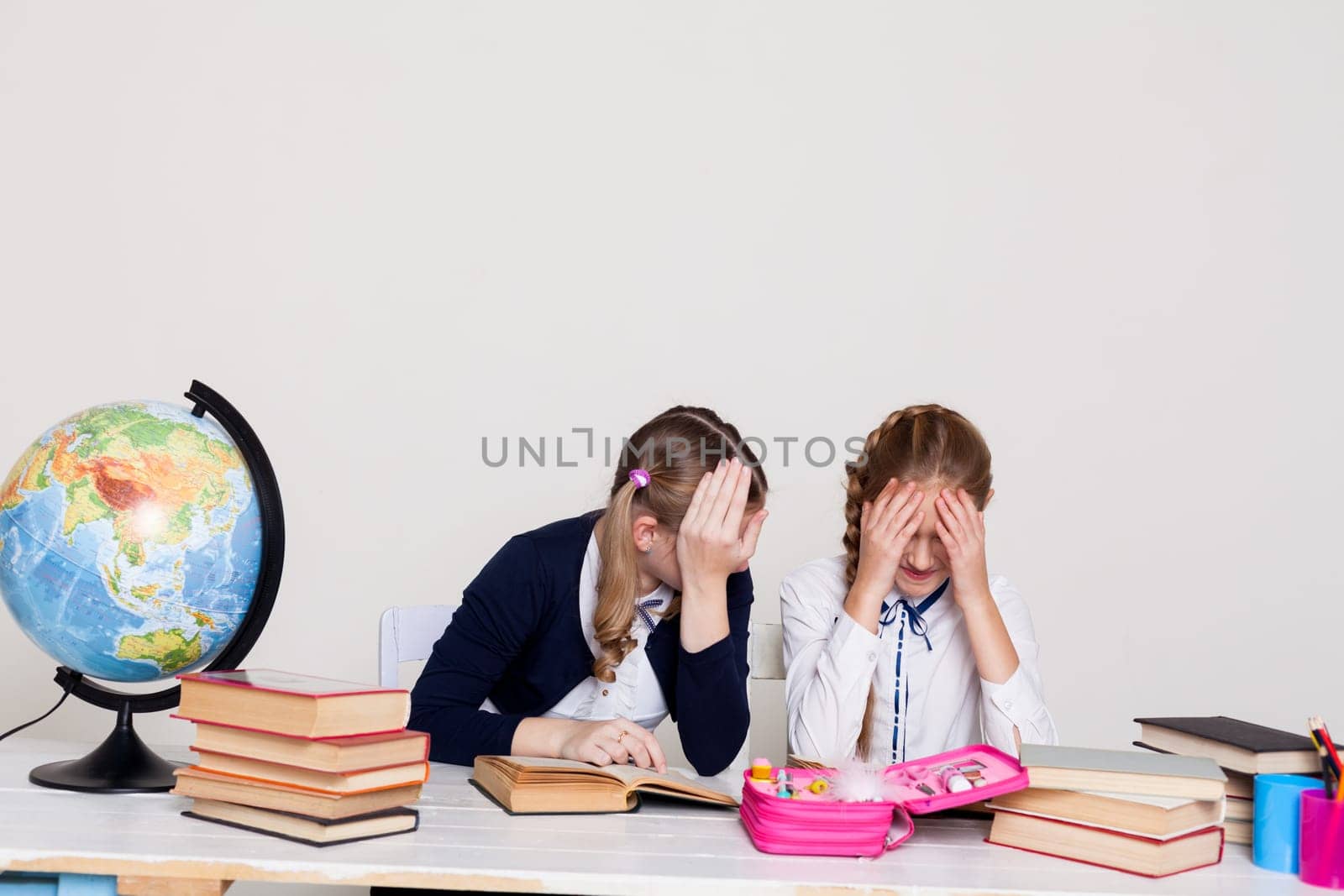 two schoolgirl at the desk in a geography class