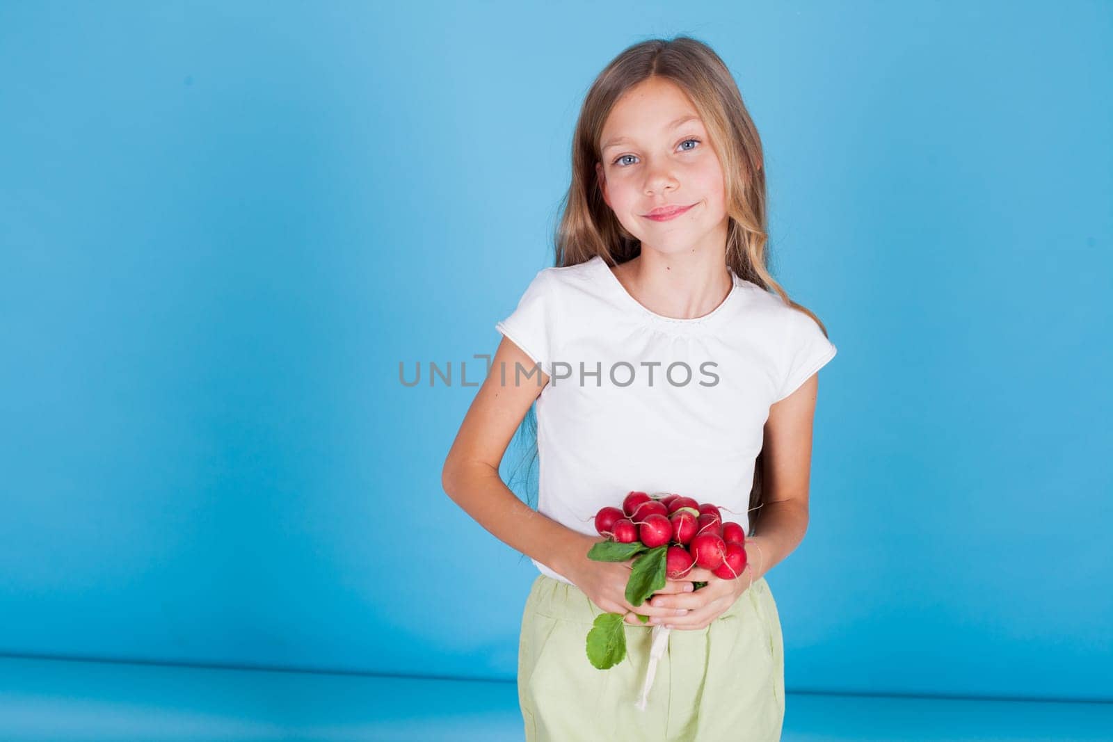 girl holds vegetables red radish in her hand