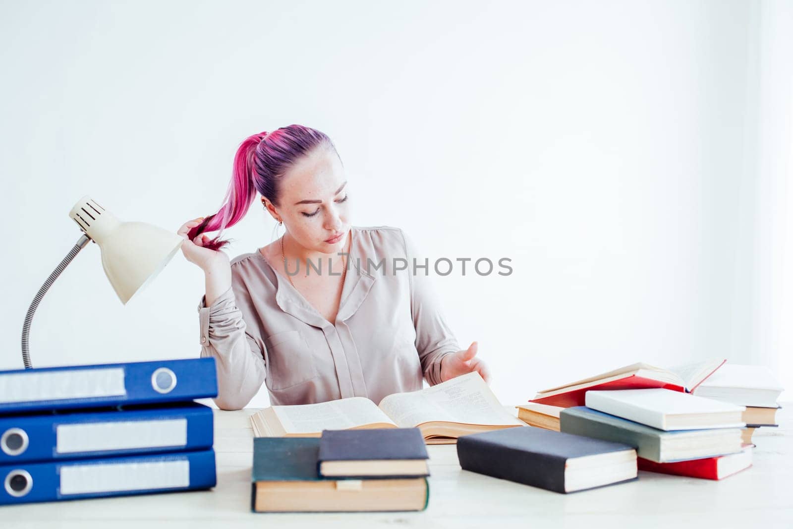 girl with pink hair sitting at a table reading a books by Simakov