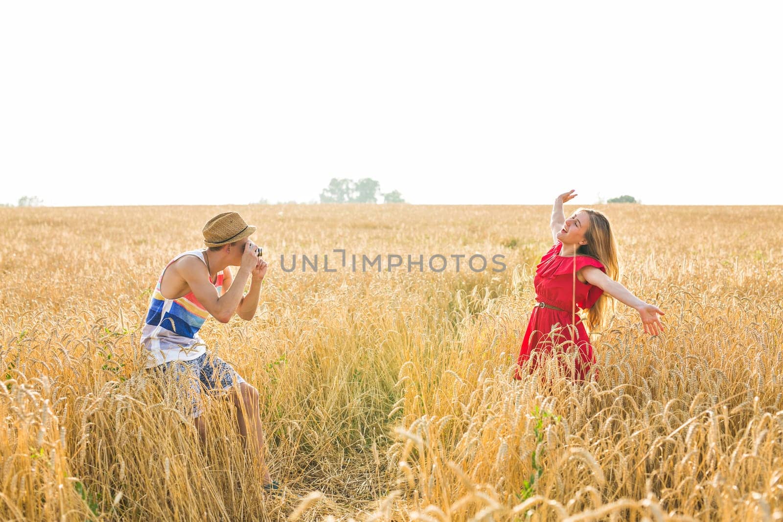 Happy outdoor portrait of young stylish couple in summer in field.