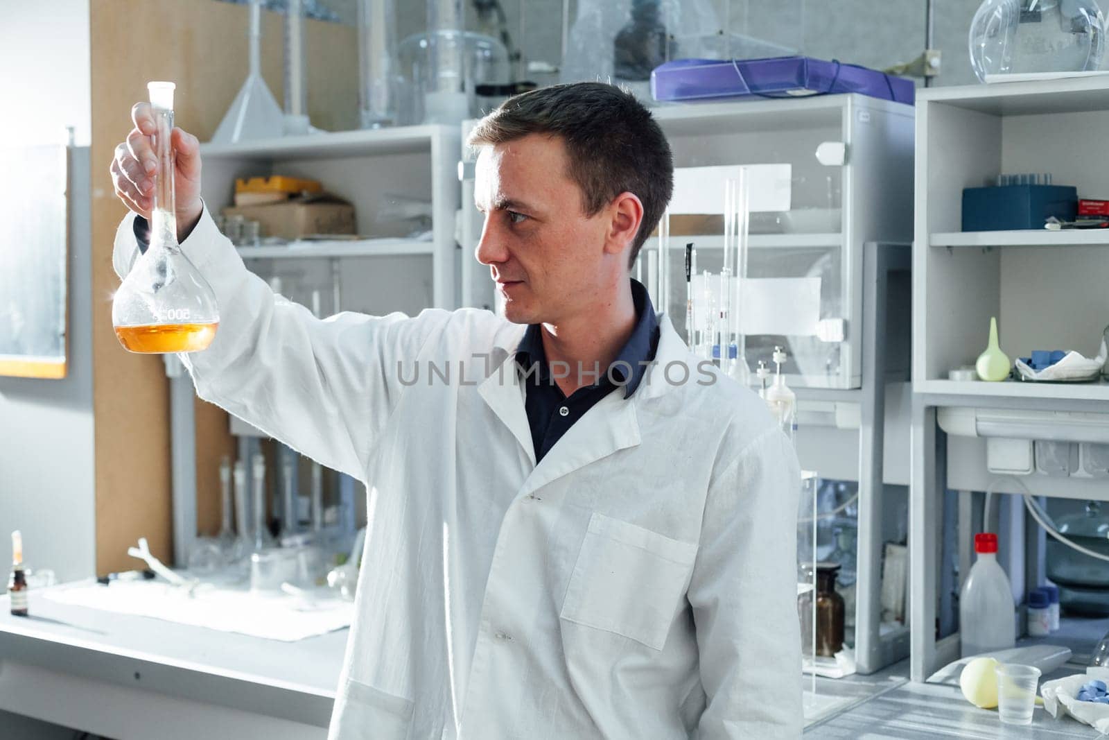 young scientist conducts chemical experiments with liquids in the laboratory by Simakov